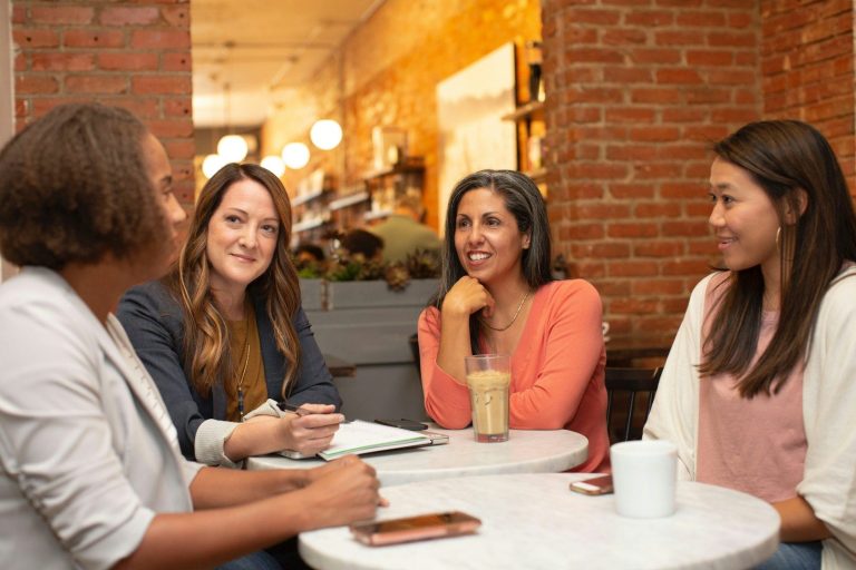 Stock Photo of women gathered around a table having a conversation